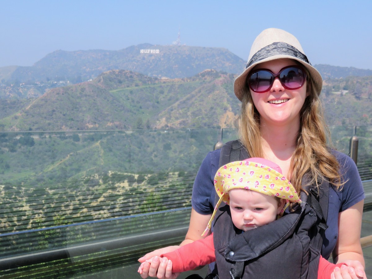 Baby in a sling in front of Hollywood Hills.