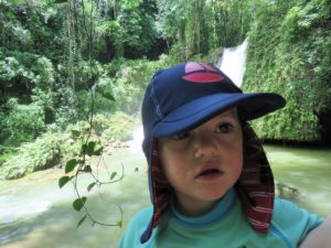 Young girl in front of waterfall in Jamaica