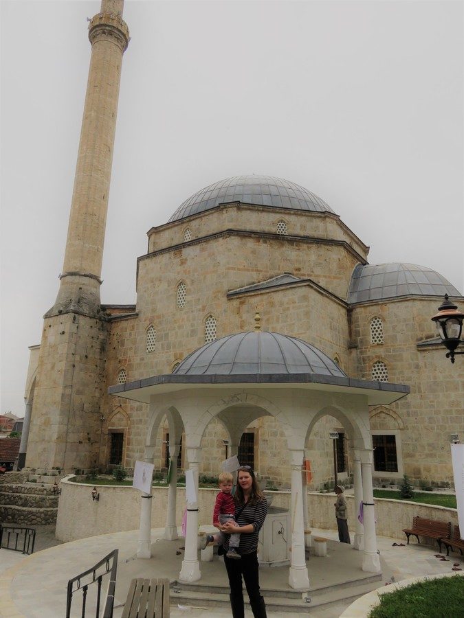 Mother holds toddler at mosque in Prizren, Kosovo