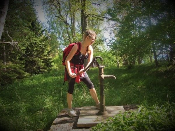 Solo female traveller pumping water in Sweden