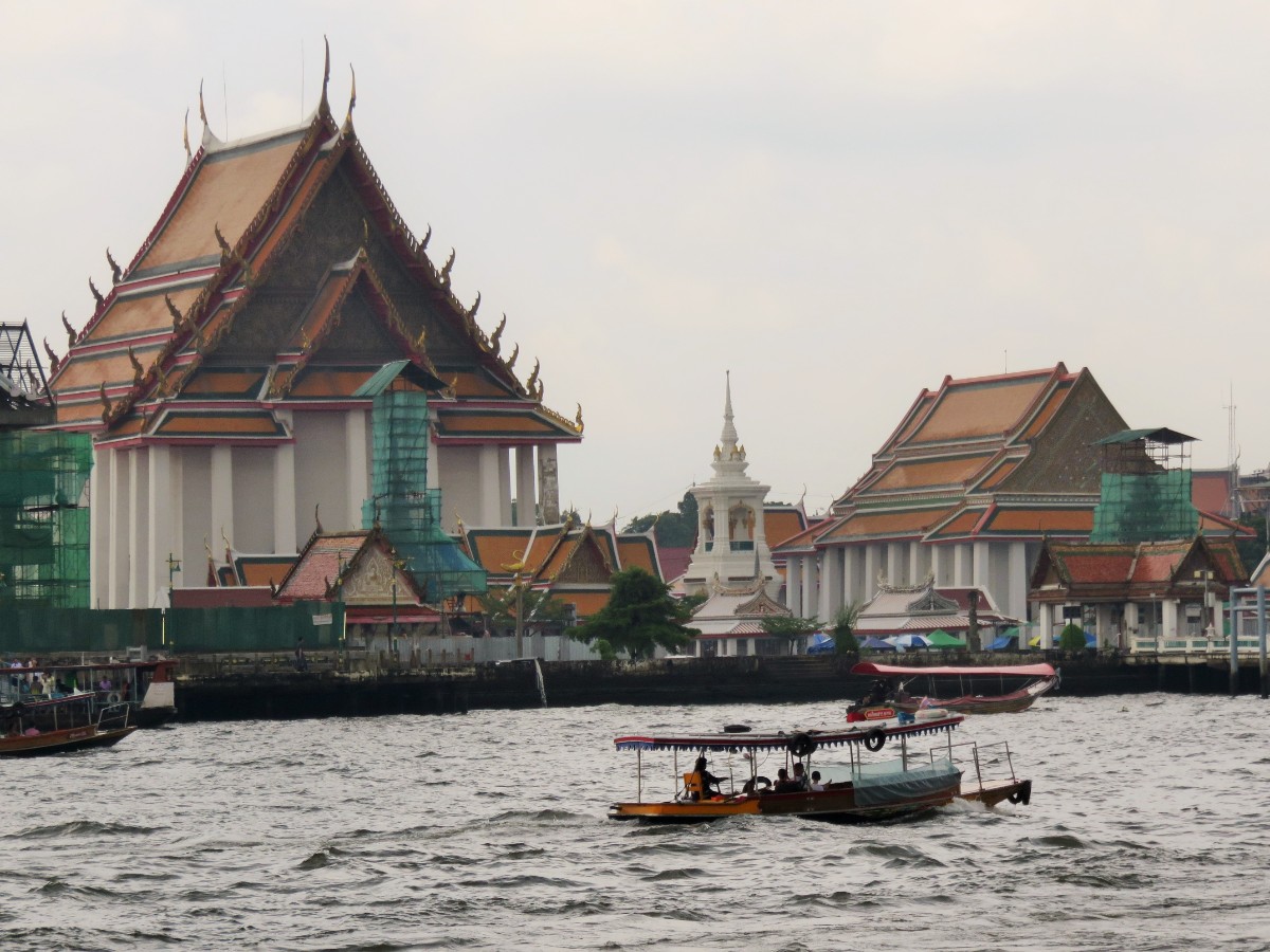 Boat on river in front of Wat in Bangkok, Thailand
