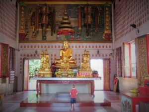 Boy looking at Golden Buddhas in Chanthaburi, Thailand