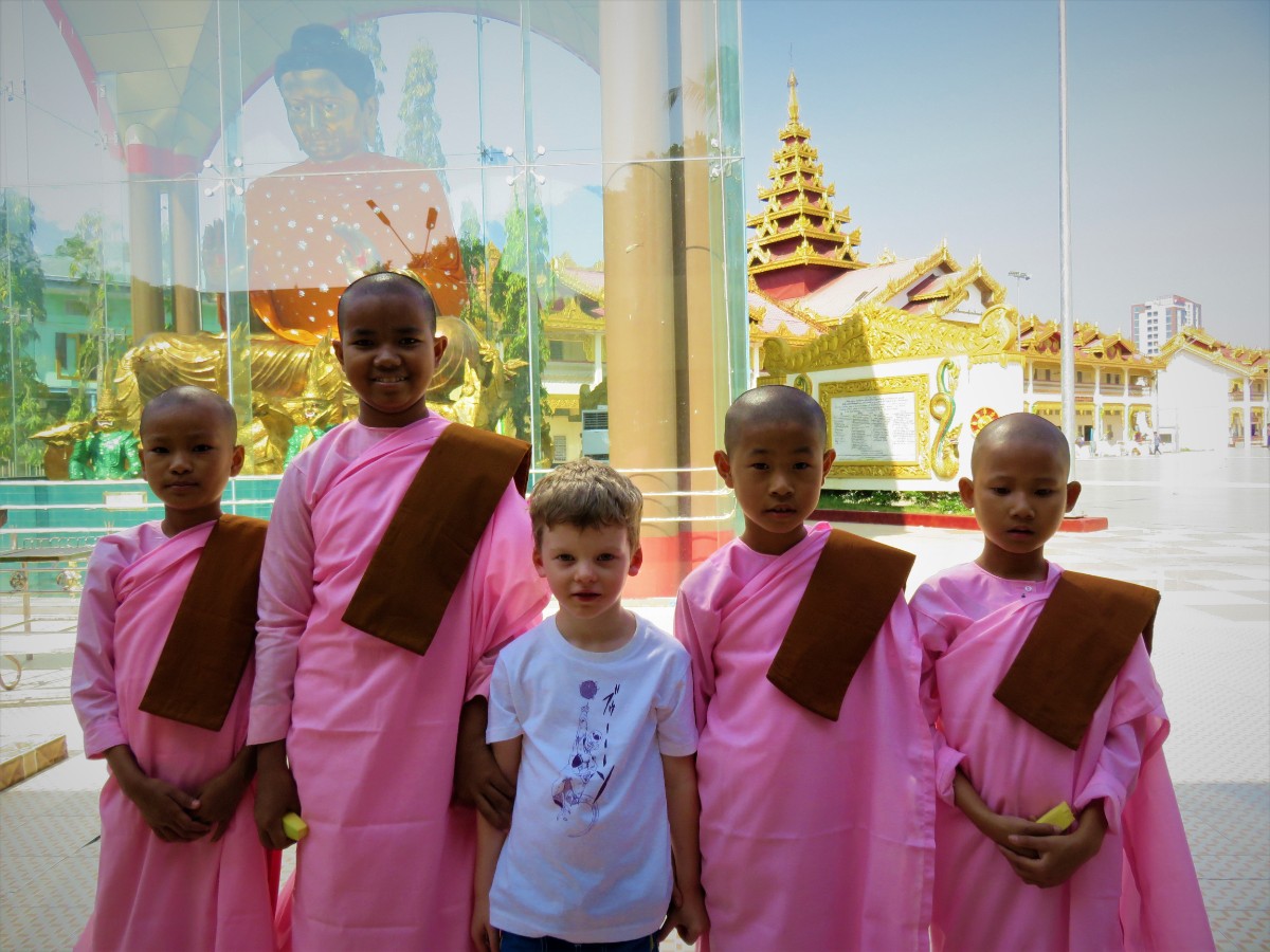 Boy posing with novice nuns in Yangon