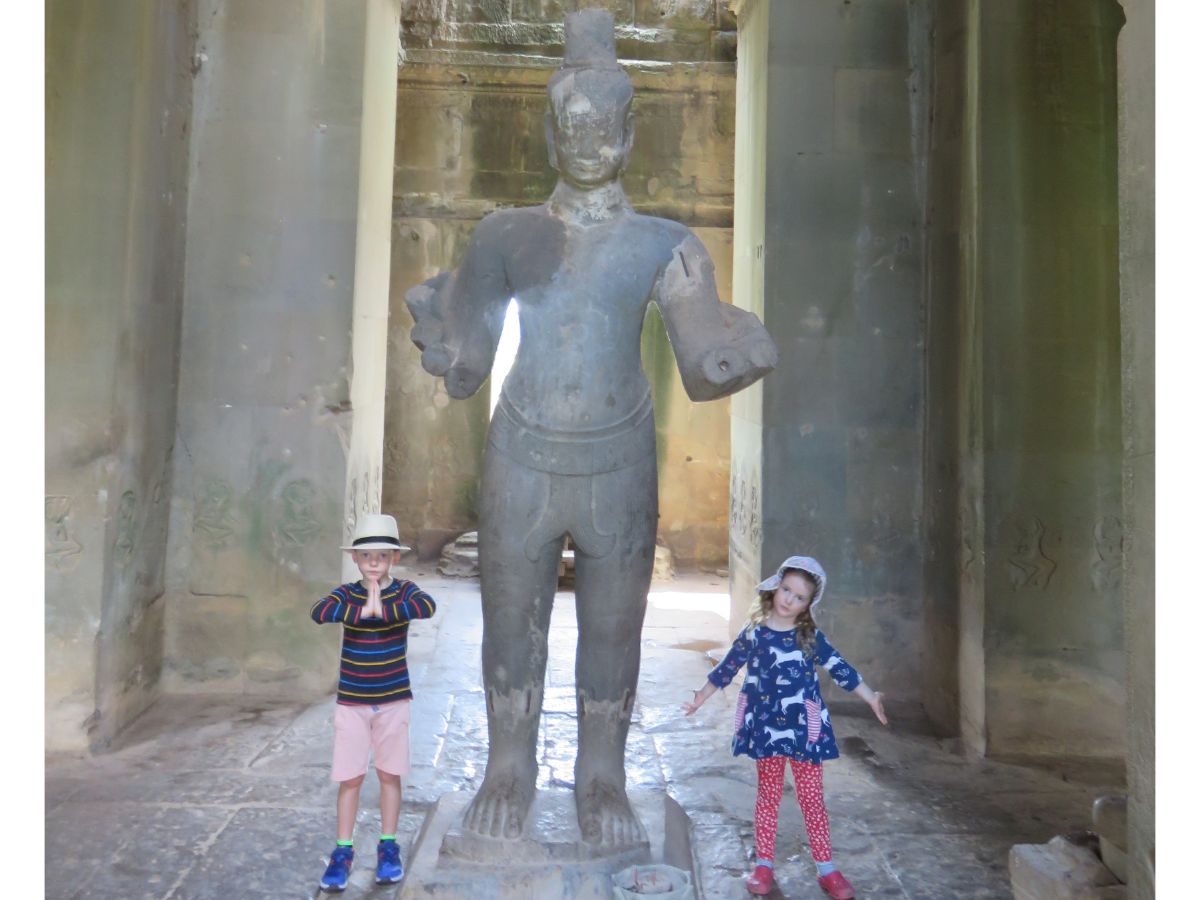 children by statue in Angkor Wat