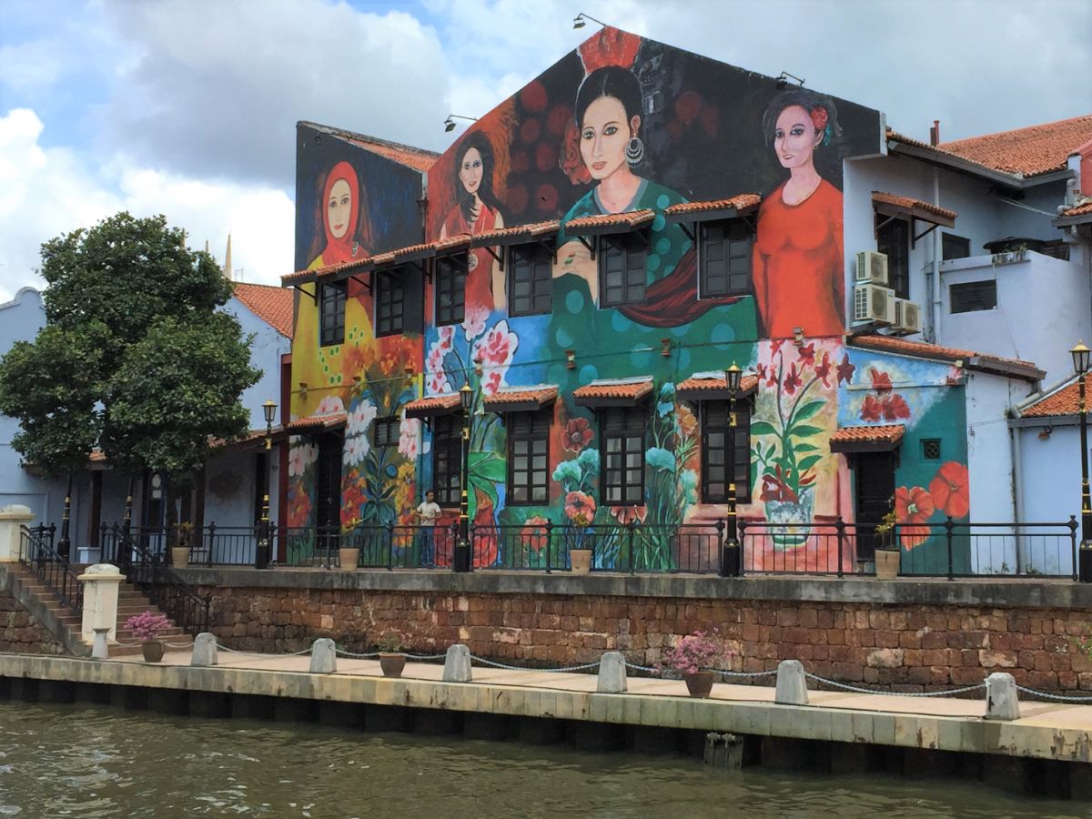 painted murals of women by river in Melaka