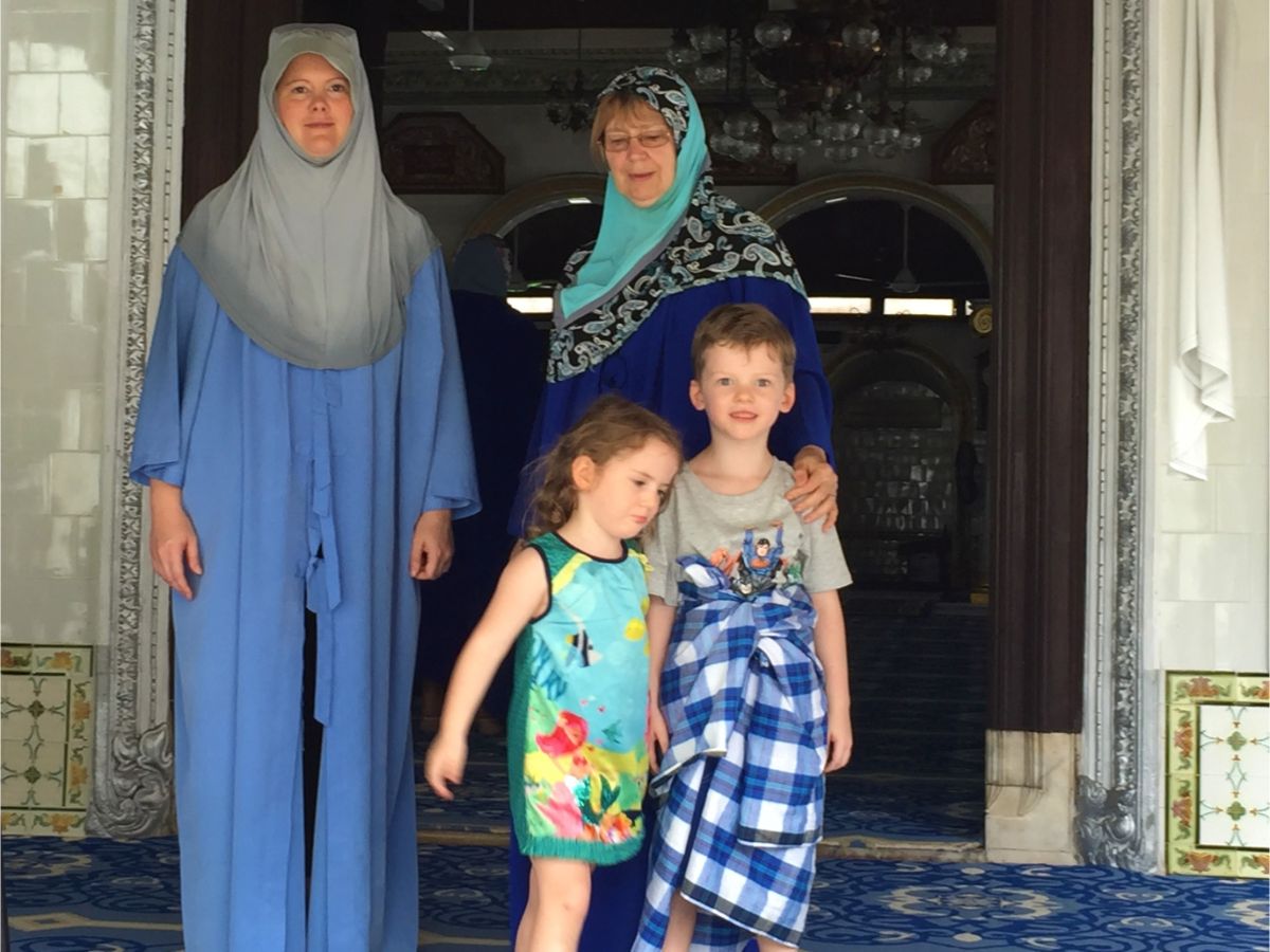 family dressed in traditional Muslim clothes at mosque in Melaka