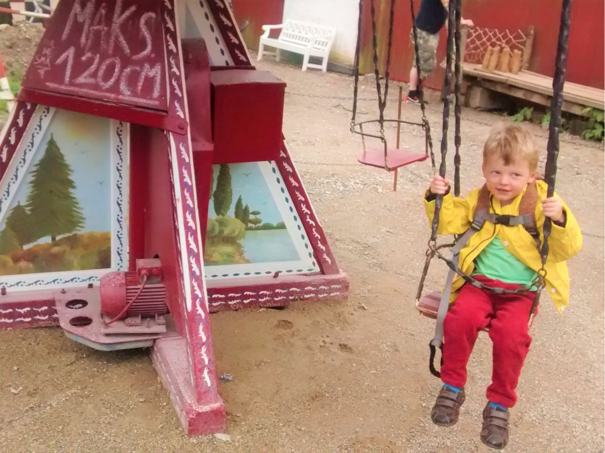 A toddler on a traditional ride at Den Gamle By in Aarhus Denmark