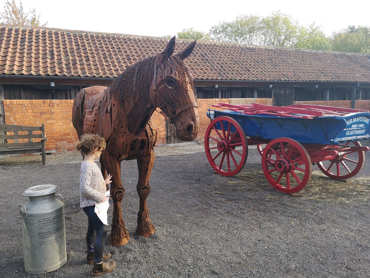toddler stroking a model of a shire horse in Somerset, UK