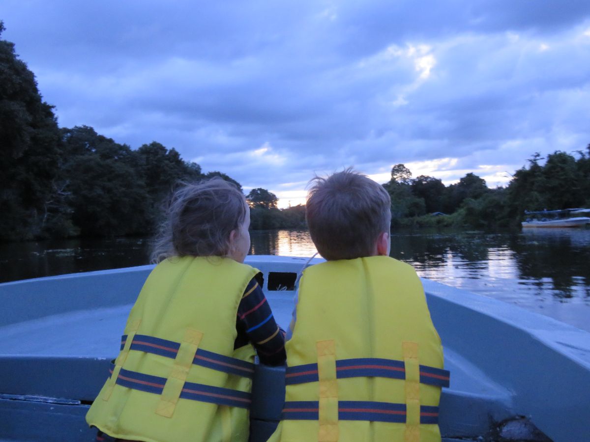 two children on a boat on the Klias River in Sabah spotting fireflies